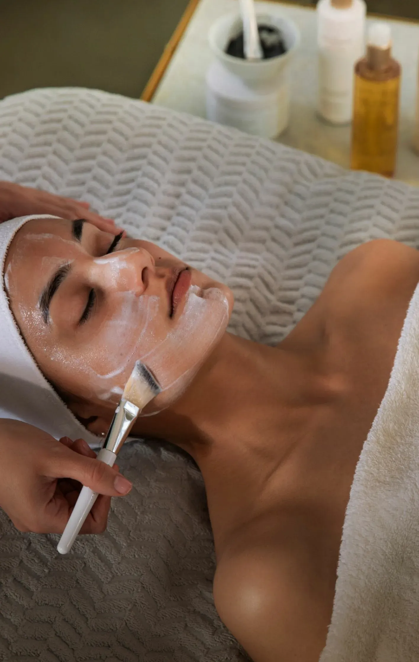 Paciente com touca recebendo aplicação de peeling facial na Clínica Dra. Simoni Bett, Joinville