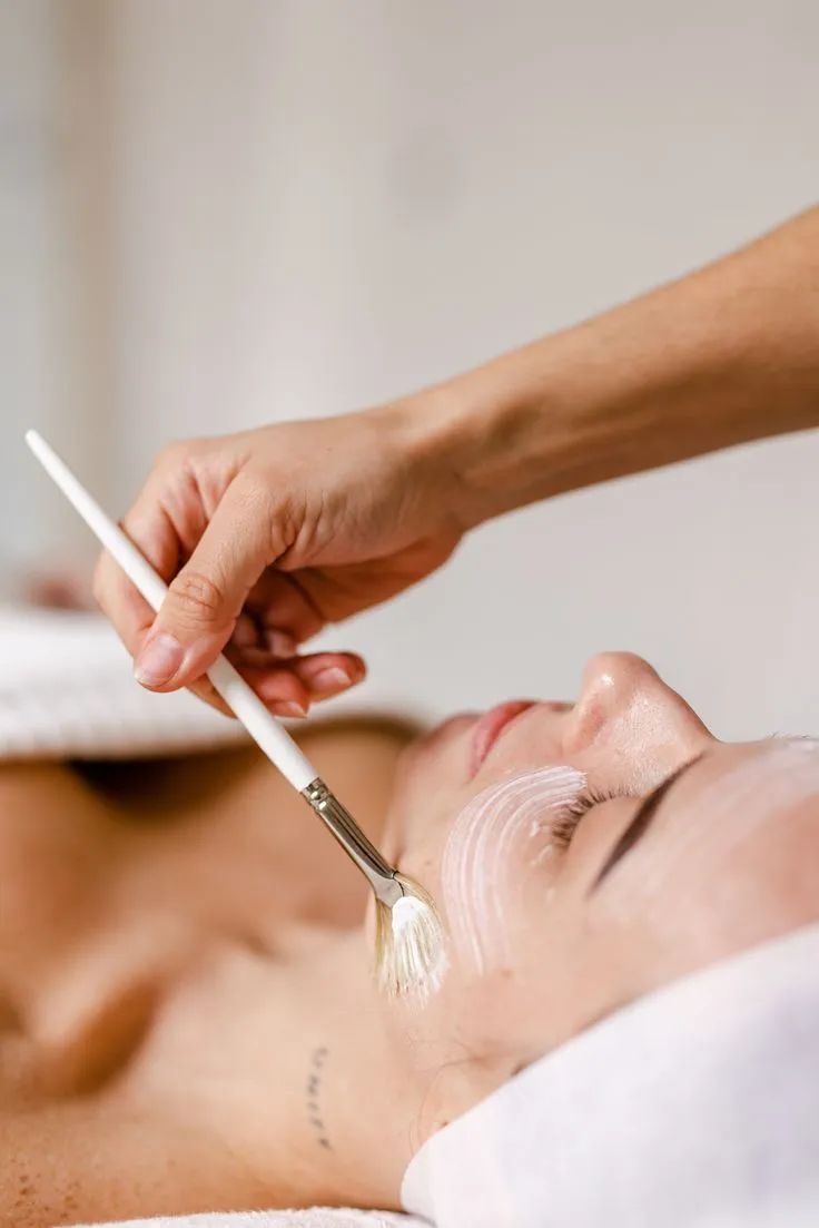 Aplicação de peeling com pincel no rosto de paciente deitada na Clínica Dra. Simoni Bett, Joinville