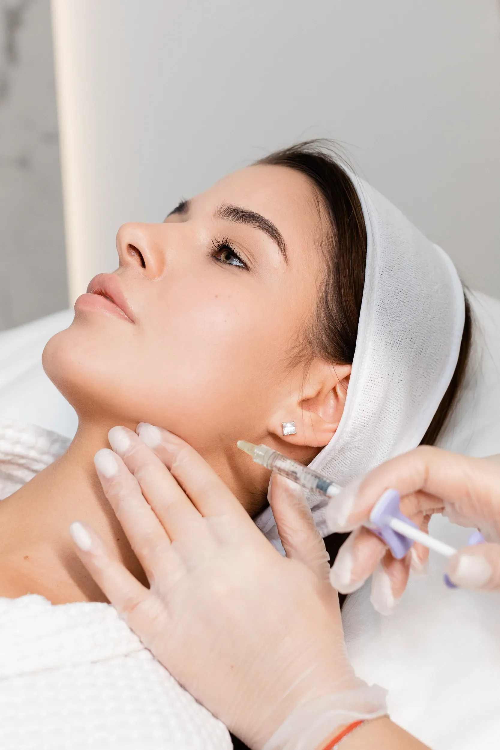 Paciente com touca em atendimento com aplicação injetável facial na Clínica Dra. Simoni Bett, Joinville
